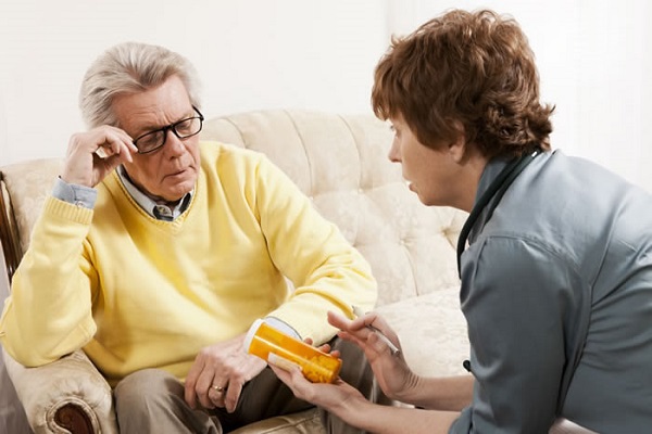 Medical provider explaining perscription instructions to elderly man